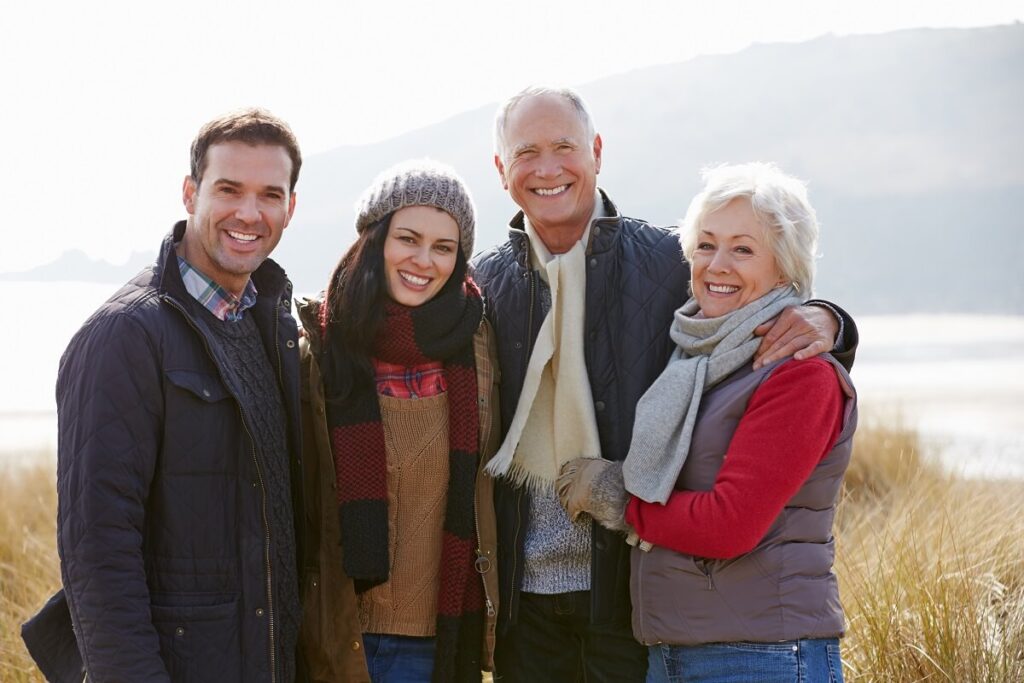 family smiling and stood together